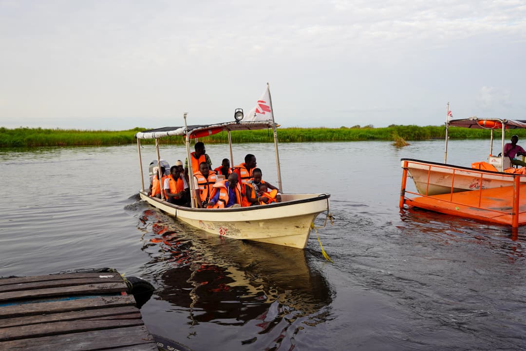 An MSF boat is near the dock, filled with people wearing life vests