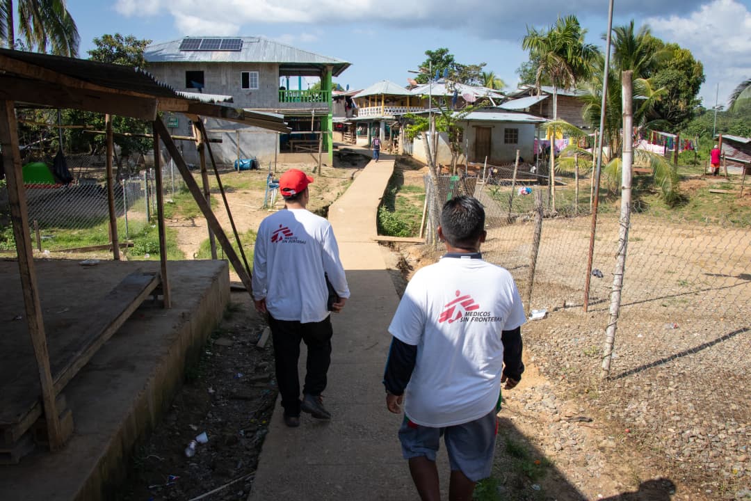 Two men in MSF shirts walk away from the camera in Panama