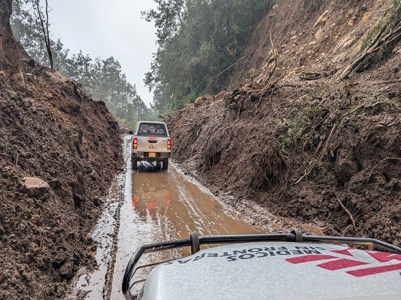 An MSF truck drives down a wet muddy ravine